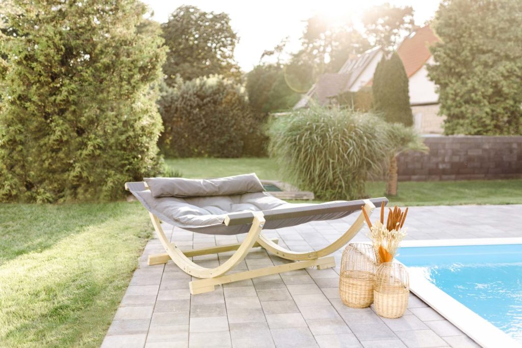 Premiumhängematte LOUNGE BED von AMAZONAS mit einem großen Gestell an einem sommerlichen Pool