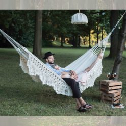 Die SALAO Tuchhängematte mit Makramee aus GOTS-zertifizierter Baumwolle mit Paar im Garten